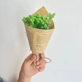 Hand holding mini green dried gypsophila bouquet wrapped in vintage newspaper with hemp rope - Vintage Mini Green Gypsophila