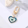Detailed view of colorful heart-shaped evil eye pendant with golden lobster clasp - Royal Blue Lake Blue Heart Eye