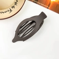 Detail view of a matte taupe oval hair claw clip on a minimalist aesthetic background - Matte Dark Coffee