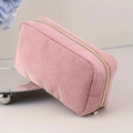 Pink corduroy large capacity makeup bag with gold zipper on a mirrored stand - Pink