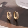 Primer plano de aretes huggie dorados con doble hilera de circonitas en engaste pavé - Estilo D9521 / Dorado