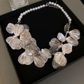 Dettaglio collana fiore in metallo argentato traforato con perle bianche in box nero - Fiore Svuotato / Argento/Bianco