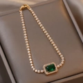 Dettaglio di un bracciale tennis dorato con smeraldo rettangolare e piccole pietre preziose - Bracciale Verde / Verde