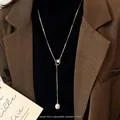 Adjustable 62cm gold chain pearl necklace shown on clothing for length and styling reference - Gold