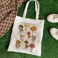 Off-white canvas tote bag featuring vintage British mushrooms botanical print on green grass - British Mushrooms & Toadstools (STD344-R)