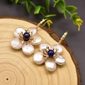 Floral earrings with baroque pearl petals and a deep blue gemstone center on wood - Lapis Lazuli Flower Earrings (Deep Blue)