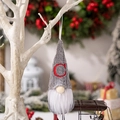 Grey knitted Christmas gnome ornament with red embroidered letter C on a white branch - Knitted Alphabet Gnome C