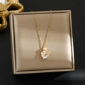Dettaglio collana con ciondolo a cigno dorato e cristalli su scatola champagne - Oro-Cigno Micro-intarsiato