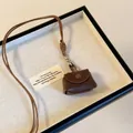 Mini monedero de cuero marrón oscuro con cordón trenzado y cierre de botón a presión - Marrón