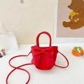 Mini red crossbody bag with large bow detail and top handle on a cute display - Red