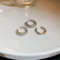 Vista dettagliata di tre earcuff in argento con zirconi su un piatto di ceramica bianca - Set di 3 Clip per Orecchie / Argento