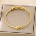Golden titanium steel cable wire bracelet with twisted texture and central oval bead - Oval Gold Bead Style (KB187905-XY) / Gold
