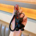 Detail van zwarte beer sleutelhanger met gevlochten leren riem en metalen ring - Zwart
