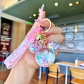 Detailed close-up of pink liquid sand keychain with Mickey shape and Happy Moments strap - White Luminous Snowflake Mickey Head