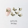 Macro view of 8x10mm golden butterfly nail charm with black detailing and pink nail model - Gold Black Pattern Butterfly Style (7175)