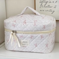 Dettaglio della borsa trucco trapuntata con fiocchi rosa, pois grigi e nastro di raso - Beauty case