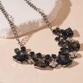 Dettaglio della collana geometrica a triangolo con strass blu e catena canna di fucile - Stile triangolo geometrico blu