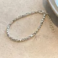 Gros plan du bracelet en perles d'argent avec fermoir mousqueton et chaîne de réglage - Style Pépites d'Argent
