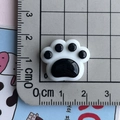 Macro-opname van zwart-witte hars kattenpoot bedeltje met afmetingen van 1,8 cm op schaal - Kattenpoot Patch / Wit Groot