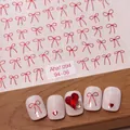 3D relief red bow nail stickers with gold accents and heart charms on glitter white nails - Aha-9406 Ribbon Bow
