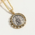 Macro del ciondolo a moneta d'oro con figura a rilievo e dettagli in zircone bianco - Floreale