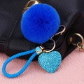 Detail of blue faux fur pompom, rhinestone heart pendant, and woven strap on gold keychain - Rhinestone Heart + Royal Blue Pom