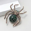 Macro view of spider brooch featuring green crystals and champagne rhinestones - Green