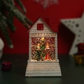 Dettaglio della casa di Natale luminosa con Babbo Natale e glitter scintillanti interni - Stile Scena Religiosa