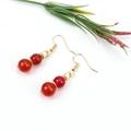 Detail view of handmade gold wire wrapped earrings with red agate crystal beads - Gold + Red Agate