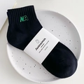 Calcetines minimalistas de algodón negro con bordado NA verde y empaque blanco - Talla única / Negro
