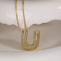 Golden letter U pendant necklace with sparkling cubic zirconia on a white plate - Letter U (Box Chain)