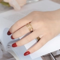 Close-up of model wearing a gold stainless steel ring with a smile cross design - Adjustable Open / Smile Face Cross Style (Gold 7)