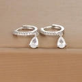 Macro shot of silver teardrop earrings with sparkling cubic zirconia on brown leather - Silver Clear Zirconia