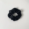 Detailed close-up of a black satin scrunchie with soft pleated silk texture and elastic core - Without Card / Black
