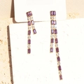 Detailed view of long gold tassel earrings with purple crystals and zircons on card - 18K Gold / Purple