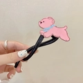 Détail de la pince à cheveux chiot rose avec finition métal noir tenue à la main - Barrette à cheveux chien rose