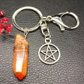 Natural orange crystal pillar keychain with star charm on black leather background - Orange (Pentagram)