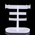 Three-tier white plastic jewelry stand for earring and necklace storage in black background - White
