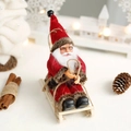 Christmas Santa Claus doll on a wooden sleigh with red velvet and fur details - Red Sled