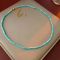 Detailansicht der blauen Perlenkette mit goldenem Metallverschluss und Verlängerung - Grün
