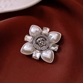 Dettaglio della spilla vintage con perle e cristalli su sfondo di seta rossa lussuosa - 9# Fiore Medusa Argento Vintage