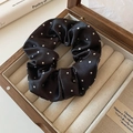 Detailed view of a black satin polka dot scrunchie placed in a wooden jewelry box - Black With White Polka Dots