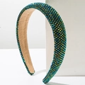 Macro detail of high crown sponge headband with colorful rhinestones on white stand - Green AB