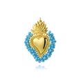 Detalle de colgante de corazón dorado con cuentas azul claro y diseño de llama en fondo blanco - Azul claro