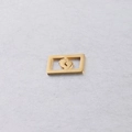 Vue macro du pendentif rectangulaire doré avec motif de empreinte de bébé ajouré - Pieds de Bébé Dorés