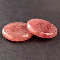 Polished strawberry quartz crystal discs showing natural inclusions on black background - Strawberry Quartz
