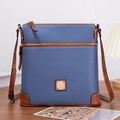 Close-up of pebble leather texture and gold logo on blue and caramel crossbody bag - Dark Blue