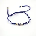 Detail of blue braided adjustable bracelet with gold heart charm and blue zircon inlay - Dark Blue