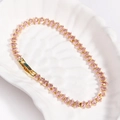 Detail of pink marquise-cut zircon stones set in a gold chain on a ceramic plate - Pink Zircon-Gold