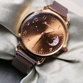 Detail of rose gold mesh watch band and sunray dial with star and moon motif - Coffee